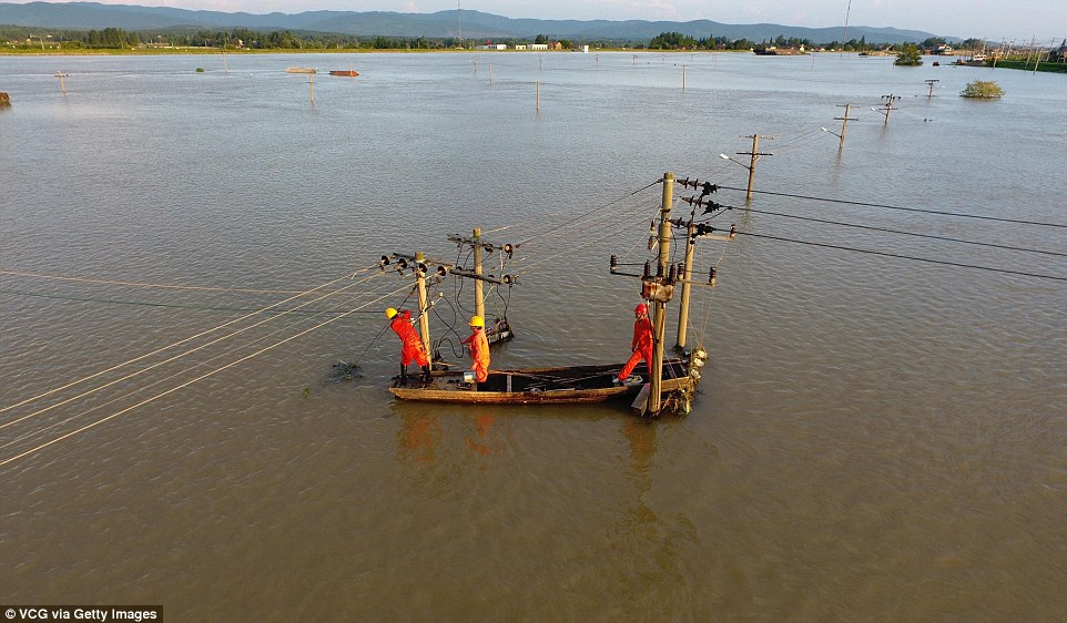 360FD6F200000578-3680615-Electricians_test_electric_poles_after_flooding_hit_the_village_-a-116_1467985581020.jpg